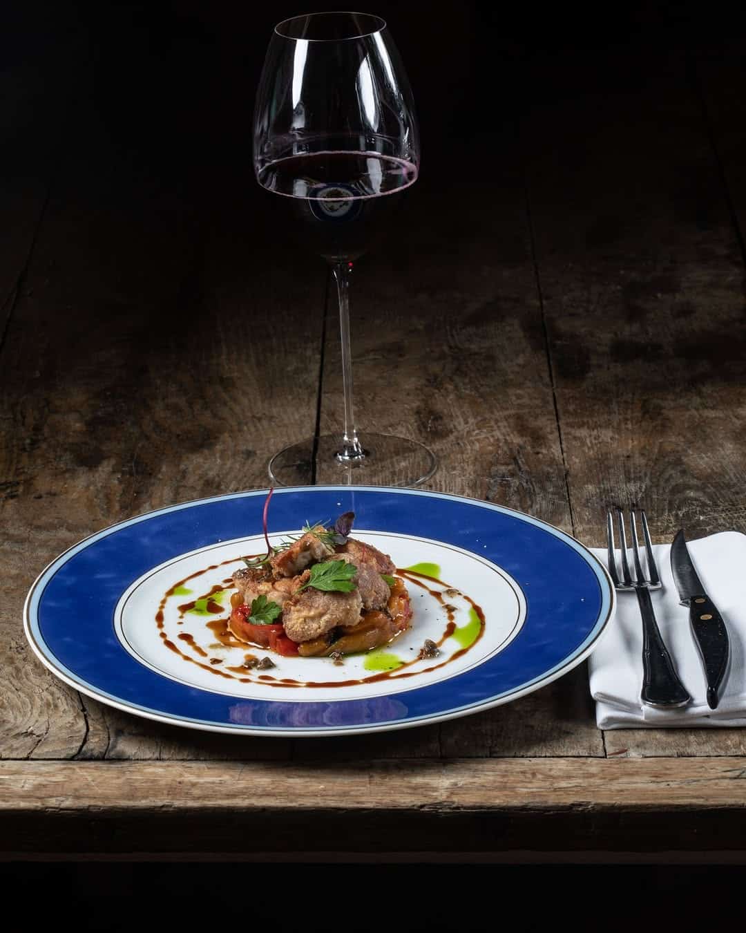Piatto della casa con un calice di vino rosso